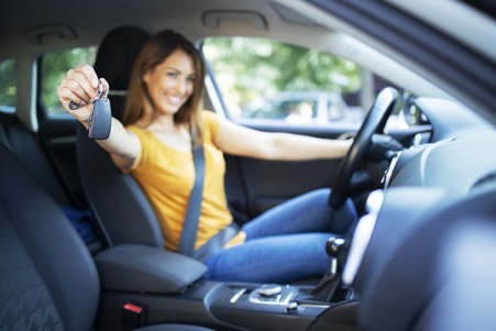 chica con mando coche