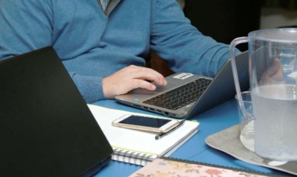 Hombre trabajando con portatil sobre escritorio