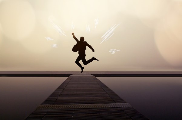 Hombre exitoso saltando en atardecer