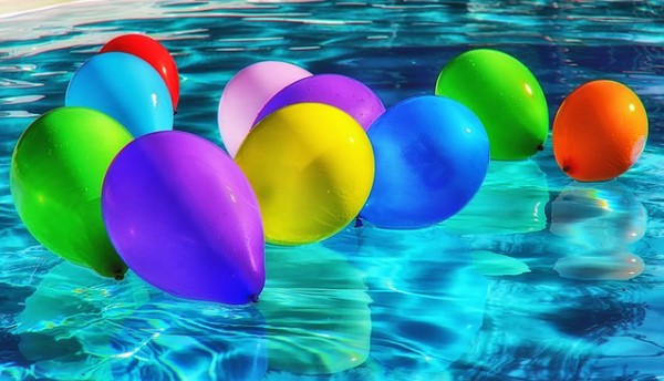 Globos de colores flotando sobre piscina
