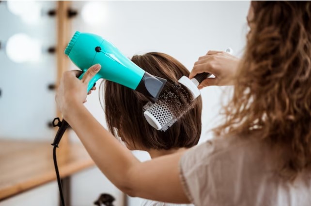 Peluquera modelando pelo de clienta