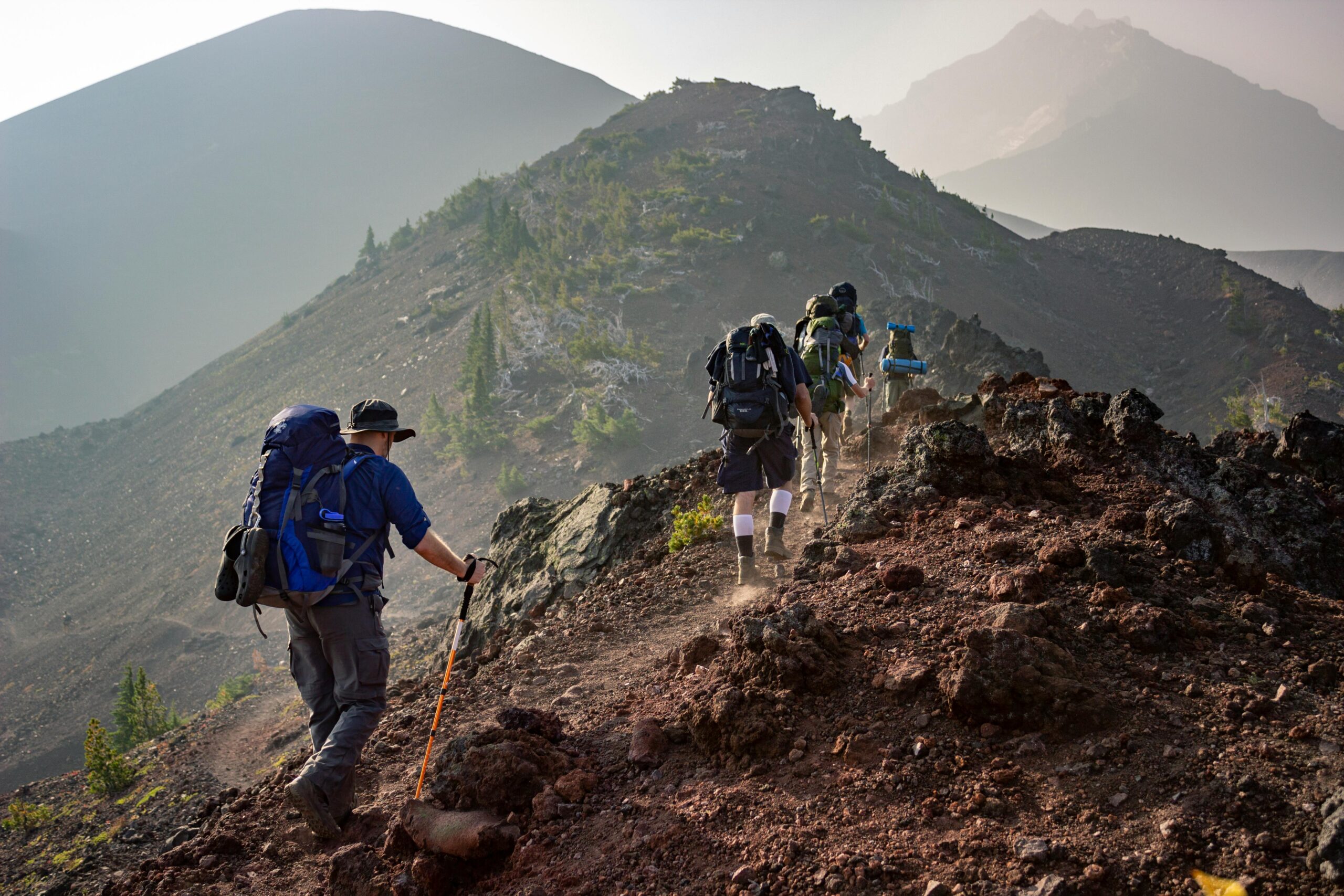 Grupo de personas practicando senderismo en montaña con mochilas