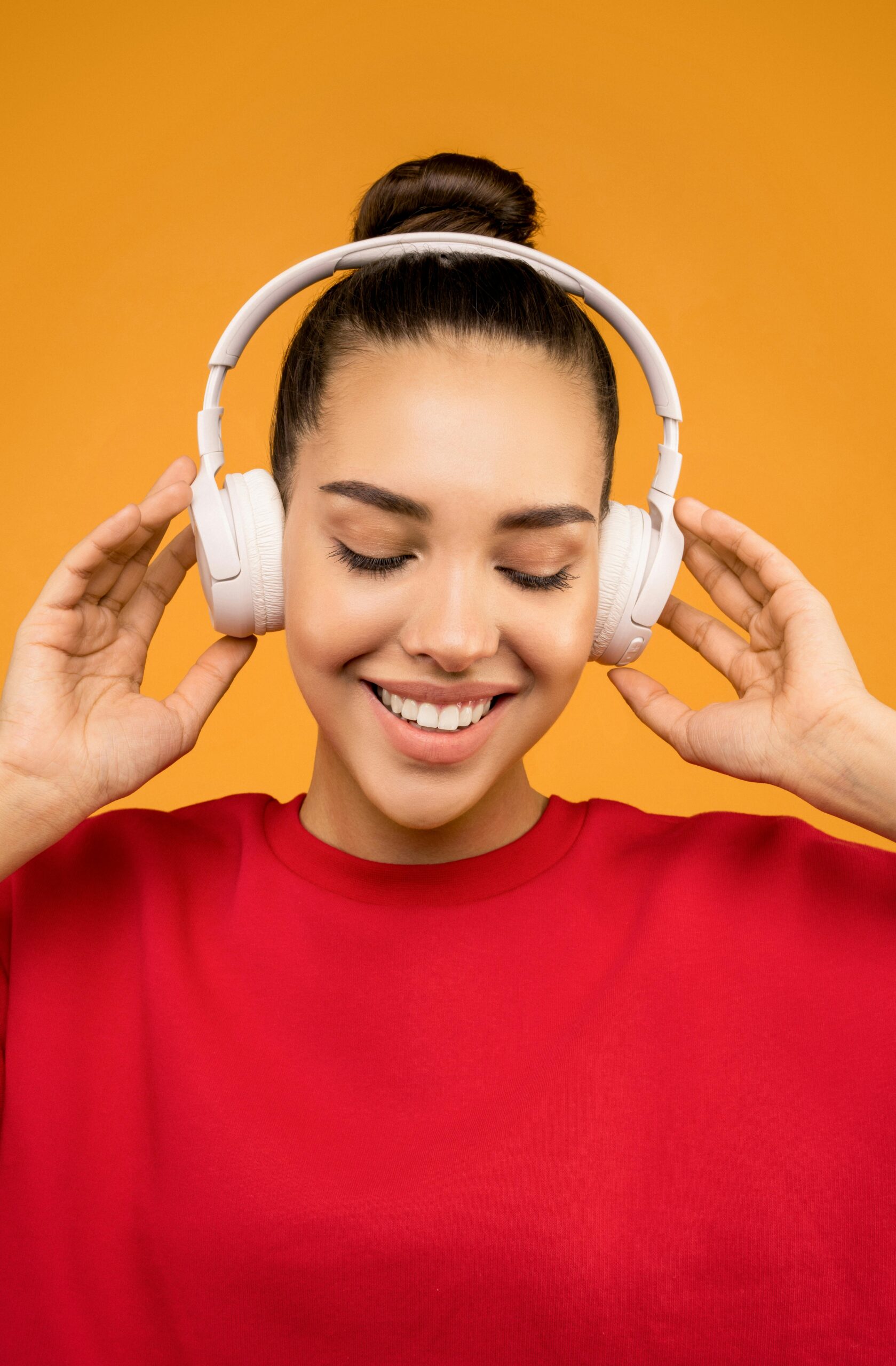 Persona escuchando podcast con auriculares en un parque tranquilo