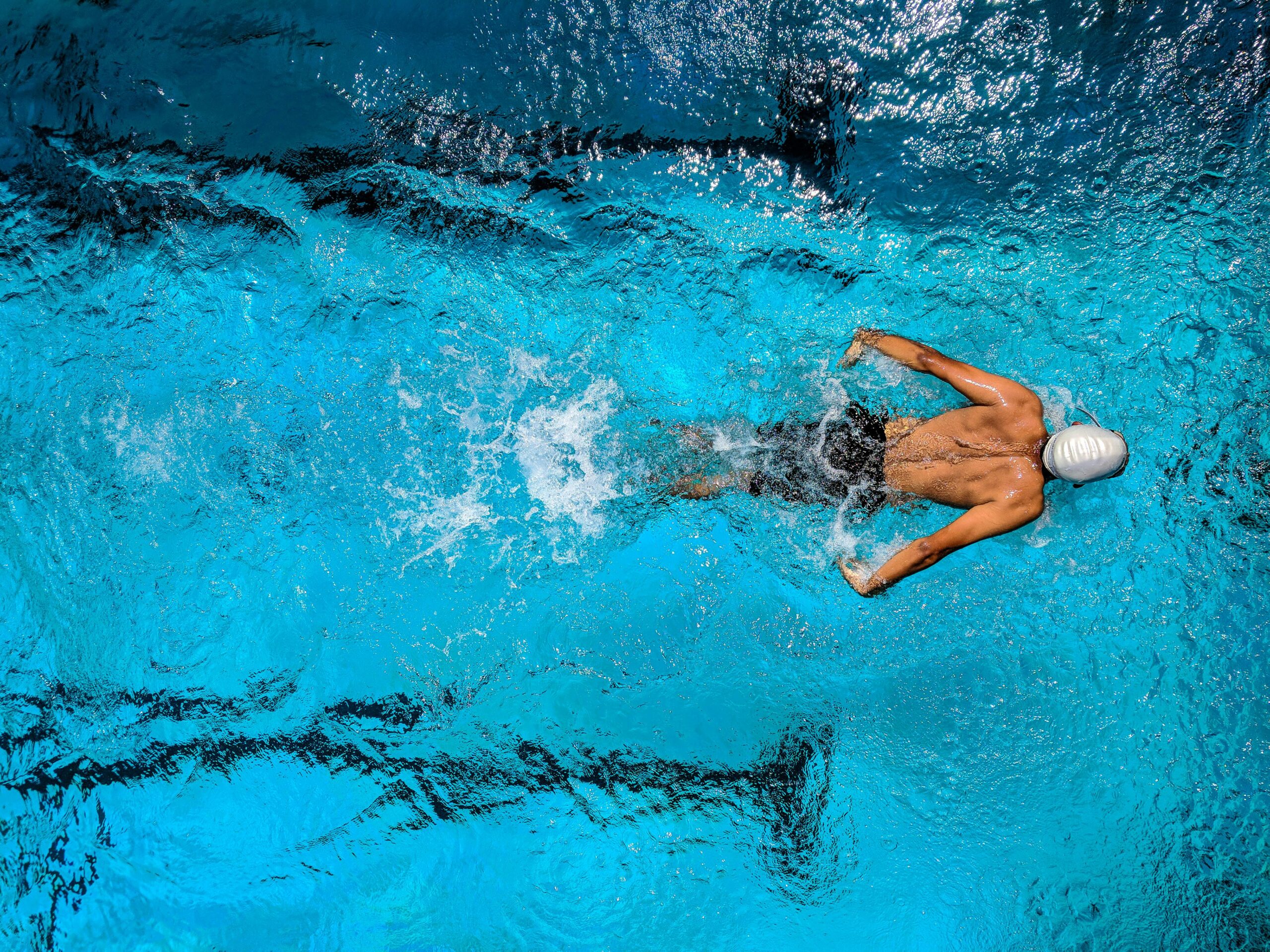 Persona haciendo ejercicios de natación con tabla de entrenamiento